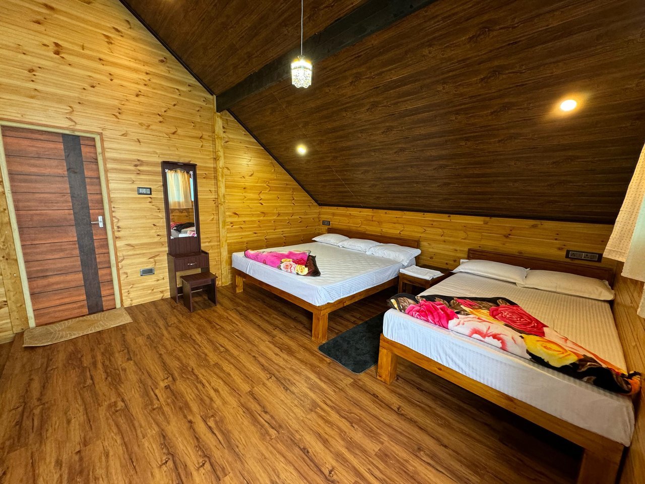 Pine-panelled room with two beds at Misty Meadows
